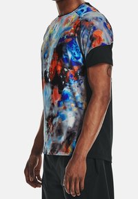 Camiseta deportiva de manga corta con un estampado abstracto colorido en azul, naranja y negro, con una textura suave y costados negros en contraste.