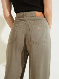 Pantalones anchos color caqui hechos de una mezcla de algodón, que cuentan con dos bolsillos traseros, un parche de cuero con el logo y un pequeño emblema en uno de los bolsillos.
