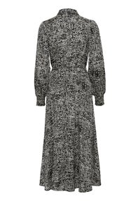 Robe à manches longues noire et blanche à motif, avec un col, une taille cintrée et une jupe fluide, présentant un design texturé.