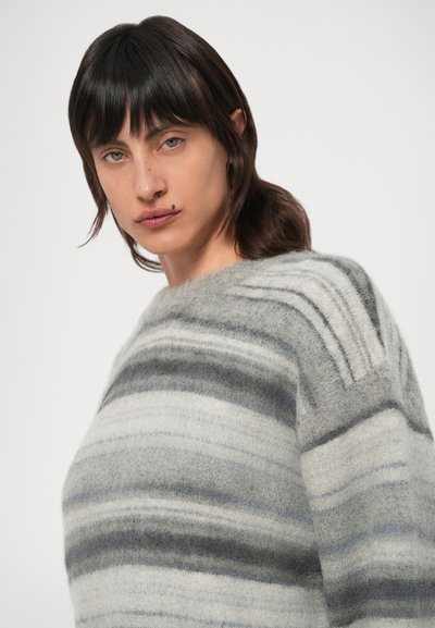 Hallide ja kooretoonidega triibuline kampsun, millel on pehme tekstuur, ümara kaeluse ja õlaliistuga detailid. Ei ole nähtavaid riistu ega kaunistusi.