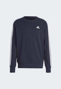 Tamno plavi dukserica s okruglim izrezom, dugim rukavima, bijelim Adidas logom na prsima i karakterističnim bijelim prugama duž rukava.