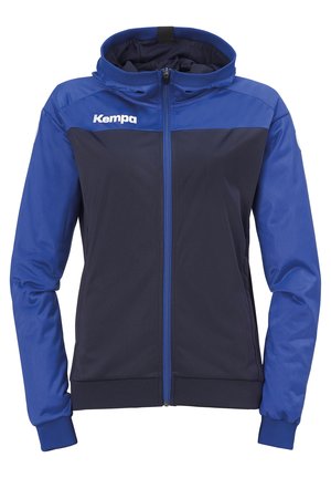 Veste zippée bleue et marine avec capuche. Elle présente des poignets et un ourlet élastiques, des poches avant et un logo sur la poitrine gauche. Texture lisse.