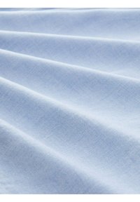 Tessuto di cotone azzurro chiaro con una texture liscia, caratterizzato da pieghe leggere e un motivo discreto e uniforme.