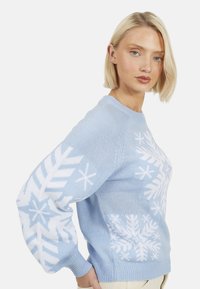 Maglione lavorato a maglia azzurro chiaro con motivo a fiocco di neve bianco, polsini e orlo a coste, scollo rotondo e maniche larghe a palloncino.