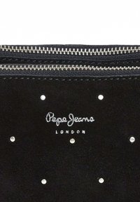 Pochette en suède noir avec quincaillerie en ton argent, deux fermetures éclair, logo brodé en argent et rehaussée de petits clous à l'avant.