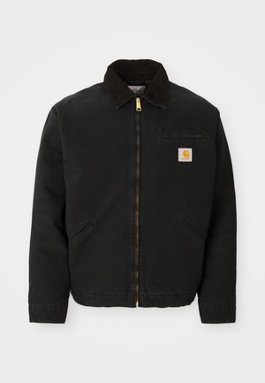Black zip-up jacket with brown corduroy collar, two side pockets, and a small square Carhartt logo patch on the left chest.