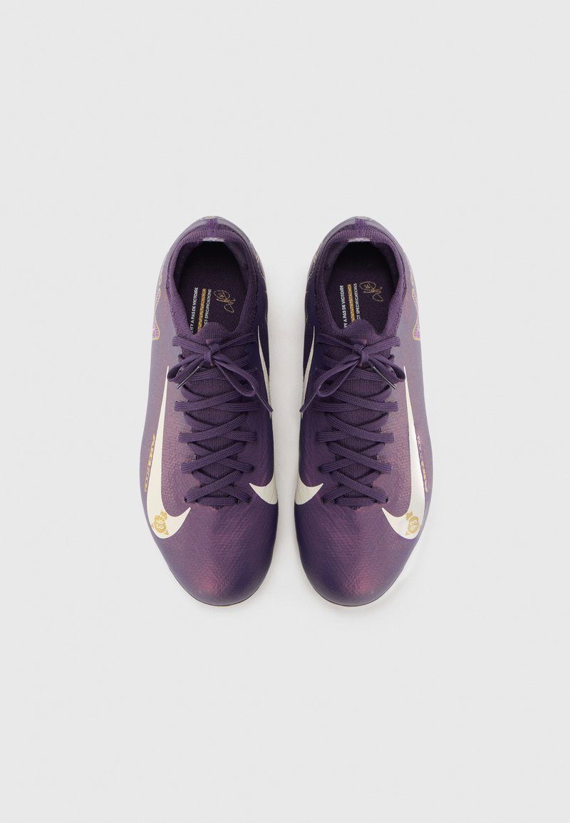 Zapatillas deportivas moradas con el swoosh blanco de Nike y acentos dorados, que presentan un upper texturizado y cordones multidireccionales para un ajuste seguro.