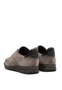 Scarpe in suede marrone con un tacco posteriore in pelle nera tessurizzata. Presentano cuciture sottili e una suola in gomma resistente per una buona aderenza.