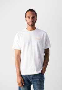 Witte katoenen T-shirt met korte mouwen, een ronde hals en een klein oranje "ANTICO BAR" logo op de linkerkant van de borst. Casual fit.