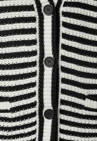 Strickjacke mit abwechselnd schwarzen und weißen horizontalen Streifen. Verfügt über fünf schwarze Knöpfe und zwei Fronttaschen.