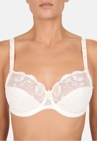 Hvid underwire-bh med gennemsigtige blomsterlacedåser, bølgede kanter og satin detaljer. Justerbare stropper med broderede detaljer.