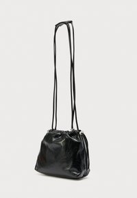 Sort læderpose med snor, lange stropper, rundet form og glat tekstur. Har en rynket åbning og sølvfarvede metaldetaljer.