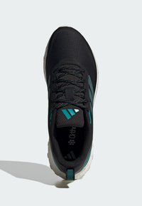 Zapatilla deportiva negra con parte superior de malla, detalles en turquesa y lengüeta texturizada. Cuenta con cierre de cordones y suela exterior blanca con salpicaduras.