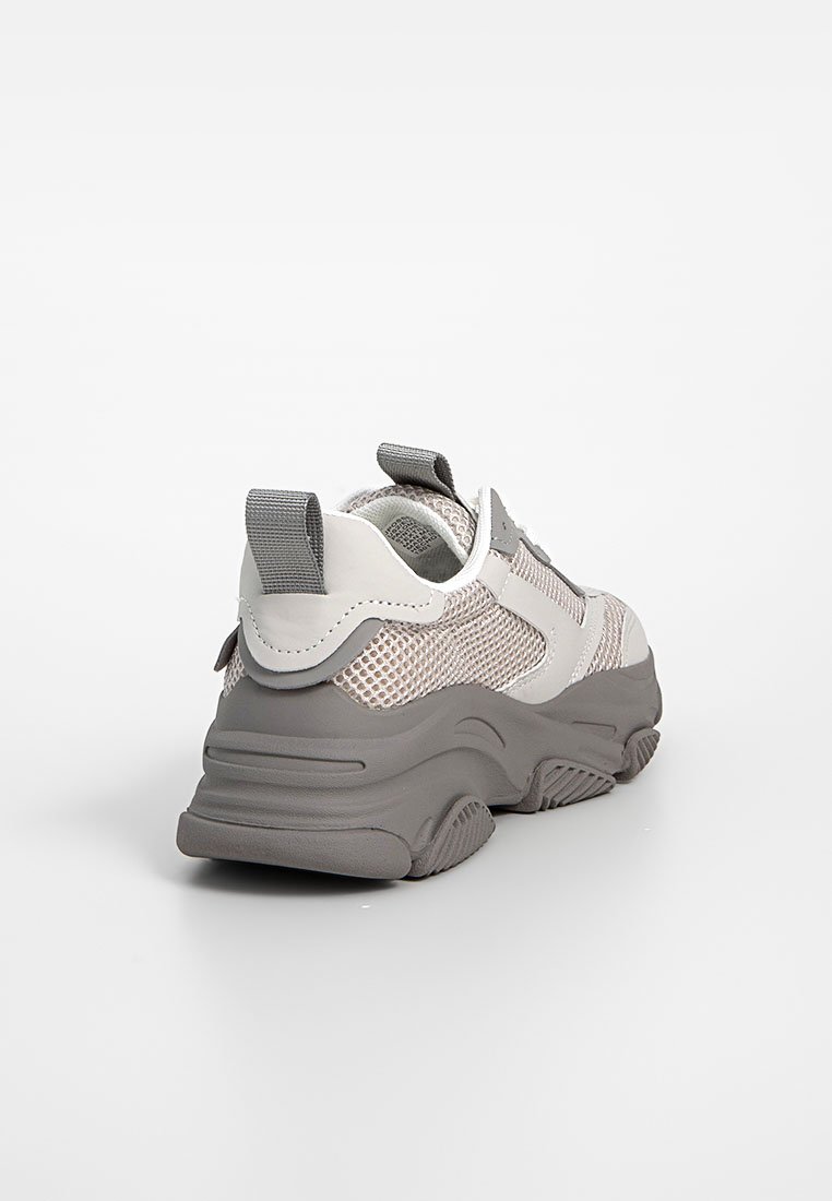 Kraftiga sneakers med en grå gummisula, ljusgrå mesh-ovandel och accenter i mörkare grått. Slip-on-design med dragtab baktill.