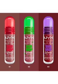 Trois tubes de gloss à lèvres présentent des embouts arrondis : rouge, vert et violet. Chacun est transparent avec une base rose et des textes décoratifs ainsi que des accents.