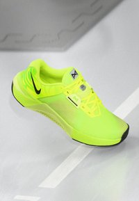 Φωτεινά κίτρινα αθλητικά παπούτσια με υφαντό mesh επάνω μέρος και μαύρες λεπτομέρειες. Διαθέτουν επενδεδυμένο περιλαίμιο, σύστημα κλεισίματος με κορδόνια και καουτσούκ σόλα.