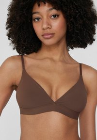 Braunfarbener dreieckiger Bralette mit dünnen verstellbaren Trägern, glatter Textur, minimaler Naht und einem schlichten Design, das eine einheitliche Farbe betont.