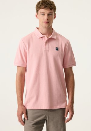 Hellrosa Poloshirt aus Baumwolle mit kleinem Logopatch auf der linken Brust, umgeschlagenem Kragen und kurzen Ärmeln.