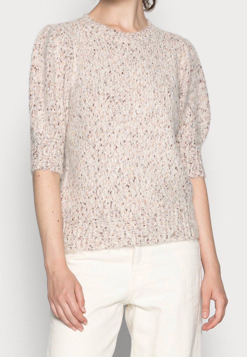 Jasno-beżowy sweter dzianinowy z krótkimi, bufkami i teksturowanym materiałem. Posiada okrągły dekolt i ściągacz na dolnej krawędzi.