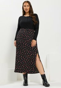 Mustapaitaiset pitkähihaiset paita, jossa on napit, yhdistettynä kukkakuosisesti mustaan maksihameeseen, jossa on sivusilmä, ja aiwis sitaen mustiin nilkkureihin.