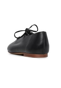 Černý kožený balerínka s tenkou hnědou podrážkou a očkem na kotníku, zobrazená z pravé zadní strany na bílém pozadí.