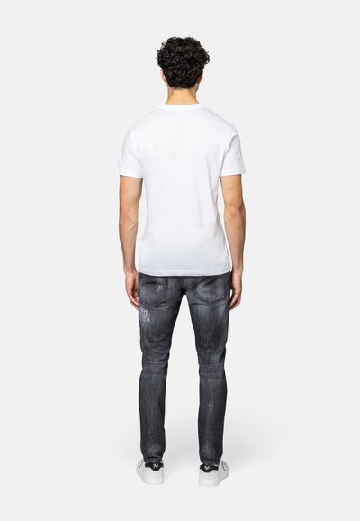 Witte katoenen t-shirt gecombineerd met donkergrijze jeans. De jeans hebben een vervaagd patroon en zichtbare stiksels, met een slim fit en achterzakken.