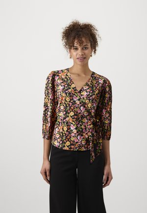 Floral wrap blouse in black fabric with vibrant pink, yellow, and green flowers. Features three-quarter sleeves and a waist tie detail.