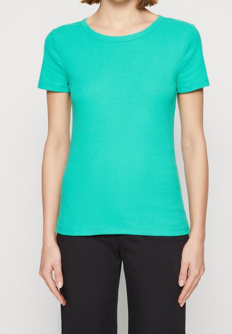 T-shirt à manches courtes côtelé de couleur turquoise vif. Présente un col rond et épouse bien la silhouette. Le tissu semble lisse.