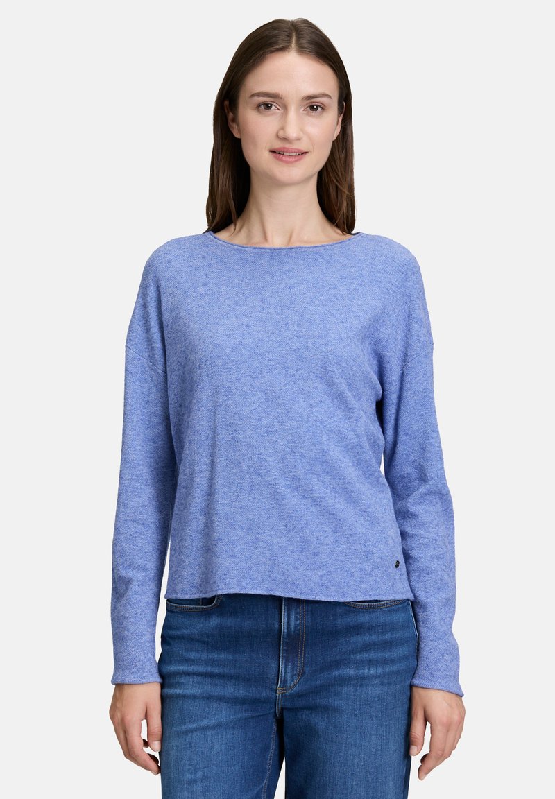 Pull à manches longues bleu avec encolure ronde, fabriqué en tissu texturé doux, présentant une coupe décontractée et un logo subtil au niveau de l'ourlet.