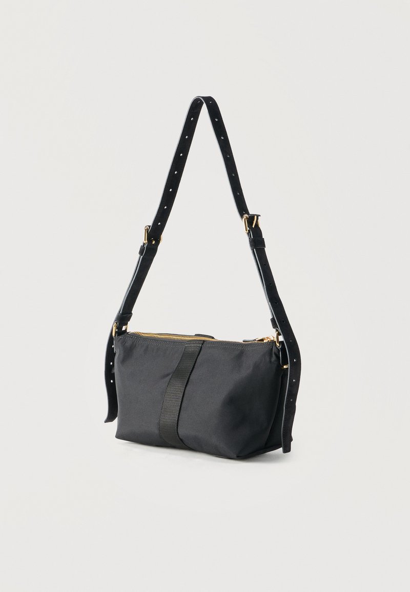 Black adjustable shoulder bag with gold zipper and hardware, rectangular shape, and a central vertical strap detail.