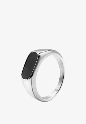 Srebrny sygnet z gładkim owalnym czarnym kamieniem osadzonym na równi na wierzchu, z polerowaną, zaokrągloną obręczą.