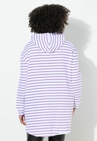 Sudadera blanca con capucha y rayas verticales moradas, de corte holgado y puños acanalados. Textil liso, sin herrajes visibles.