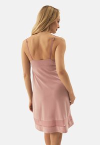 Rosa Slipdress mit dünnen, verstellbaren Trägern, glatter Textur und geschichtetem Saumdetail. Minimalistisches Design, Rückansicht sichtbar.