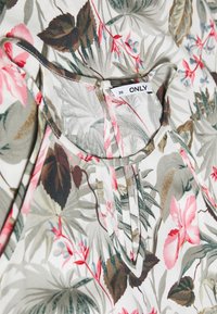 Blusenoberteil aus leichtem Stoff mit einem Mix aus Pink, Grün und Beige. Auffällige Details sind Falten und ein Etikett mit der Aufschrift "ONLY".
