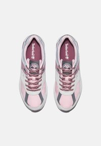 Rosa och vita sneakers med mesh- och mockamaterial. Har grå detaljer, vadderad tunga och snören med en glänsande finish. Timberland-logotypen är närvarande.