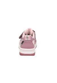 Rosa Sportschuh mit schlankem Design, strukturiertem Obermaterial und verstellbarem Klettverschluss. Die Sohle ist weiß mit pinken Akzenten.