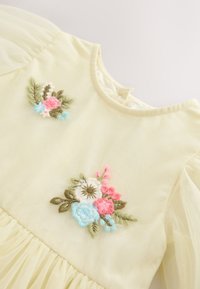 Hellgelbes Kleid mit Puffärmeln, verziert mit Blumenstickerei in Rosa, Blau und Weiß. Der geraffte Saum verleiht dem Design Textur.