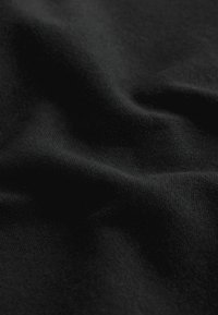 Black fabric with a smooth texture, displayed in folds. The material appears lightweight and has a subtle weave pattern.