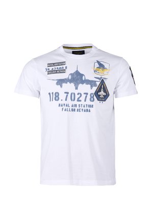 Hvid T-shirt med blå militærflygrafik, tekst "Naval Air Station Fallon Nevada" og luftfartsrelaterede mærker på front og ærme.
