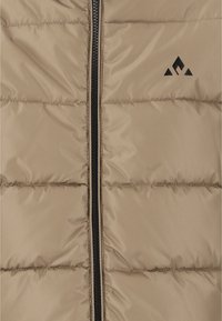 Beige puffer vest med quiltet tekstur, sort lynlås lukning og et lille sort logo med trekantede former på venstre bryst.