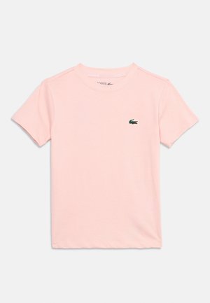 Lichtroze korte mouw T-shirt met ronde hals en een klein groen krokodillenlogo op de linkerborst, plat gelegd op een witte achtergrond.