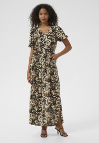 Sukienka maxi w leopardzi wzór, z krótkimi rękawami, dekoltem w serek, elastyczną talią, bocznymi kieszeniami i rozcięciem do uda. Materiał wydaje się gładki.