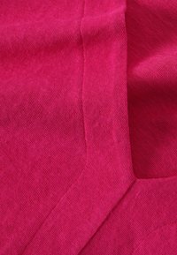 Fuchsia stof met een gladde textuur, voorzien van diagonale weefpatronen en een gevouwen randdetail.