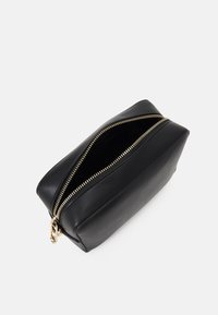 Pochette nera in pelle con zip dorata e hardware, forma rettangolare, texture liscia e un ampio interno visibile attraverso la zip aperta.