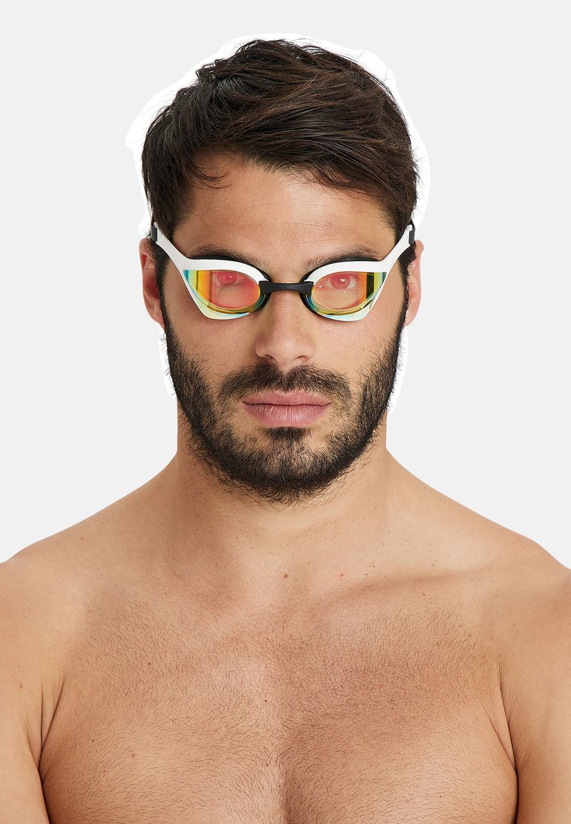 Svartvita simglasögon med tonade orangea och gula linser, med en snygg design och texturerad ram, bärs av en person utan tröja.