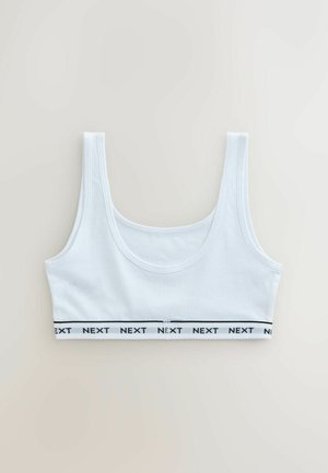 Biały krótki top na szerokich ramiączkach z elastyczną gumką na dole, z nadrukiem powtarzającego się czarnego napisu "NEXT".