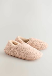 Rosa gestrickte Hausschuhe mit einem strukturierten Muster, plüschigem Kunstfellfutter und einer sanften, abgerundeten Zehenpartie. Rutschfeste Sohlen bieten Komfort und Wärme.