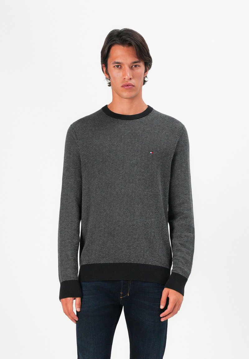 Grauer Langarm-Pullover mit Rundhalsausschnitt, der ein Fischgrätmuster aufweist, mit einem schwarzen gerippten Kragen und Bündchen sowie einem kleinen Logo auf der Brust.