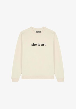Crèmekleurige sweater met ronde hals met zwarte tekst "she is art." gecentreerd op de voorkant, en een klein label met "MIRA PARIS" aan de binnenkant van de kraag.