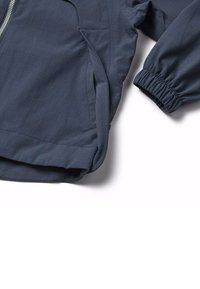 Giacca leggera navy con finitura testurizzata, polsini elasticizzati, chiusura con zip e tasche laterali, che mostra un design minimalista.